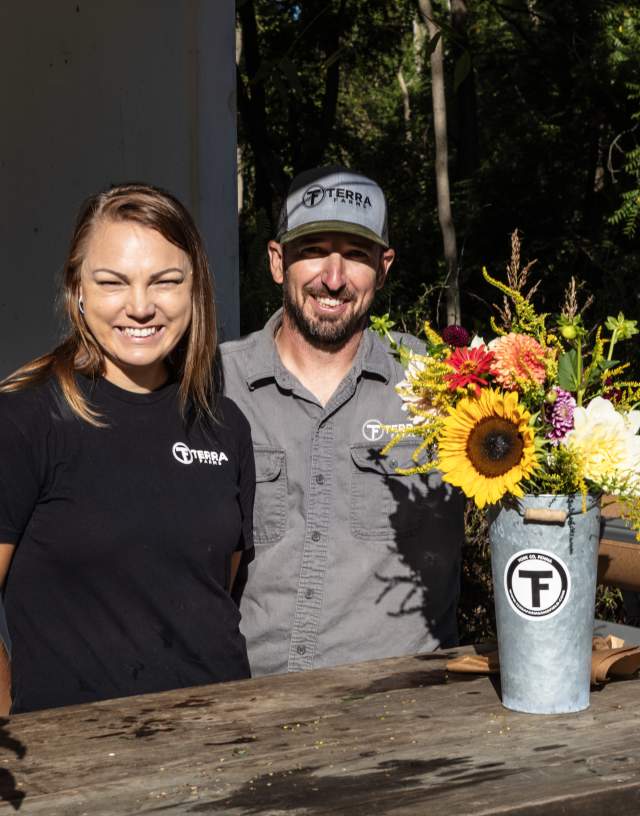The owners of Terra Farms happily standing behind the counter at the farm