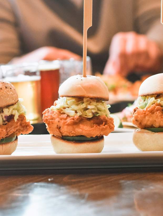 chicken sliders with people eating in the background