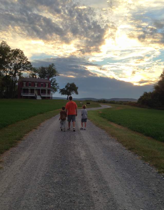 Man and two boys walking down a dirt road at the Monocacy National Battlefield