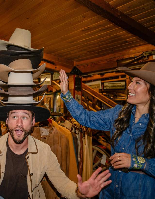 Friends trying on cowboy hats in Sheridan.
