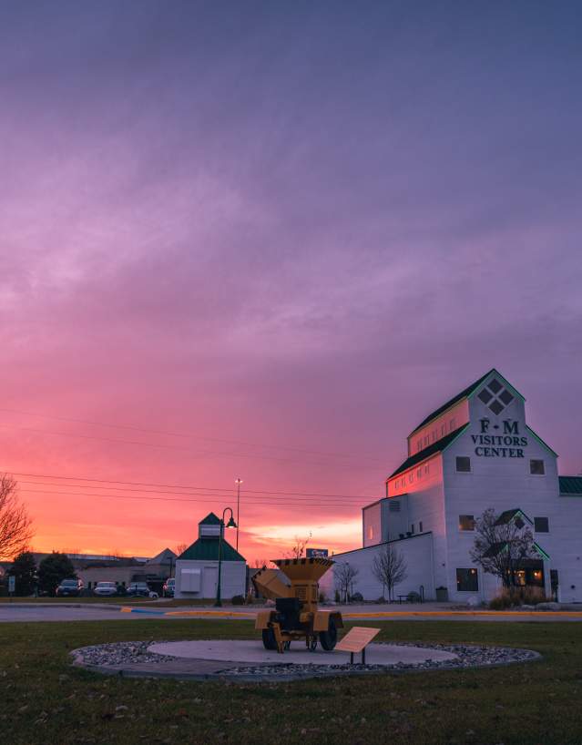 white grain elevator-type building during a purple and pink sunset
