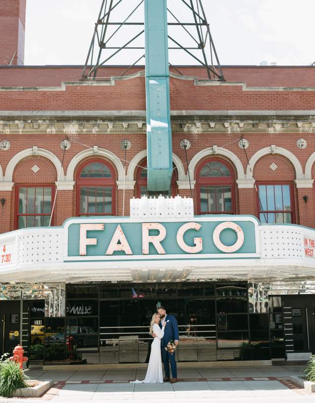 couple under the fargo theatre sign on their wedding day