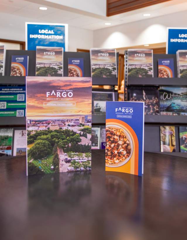 Fargo visitor guide and dining guide in front of brochure racks