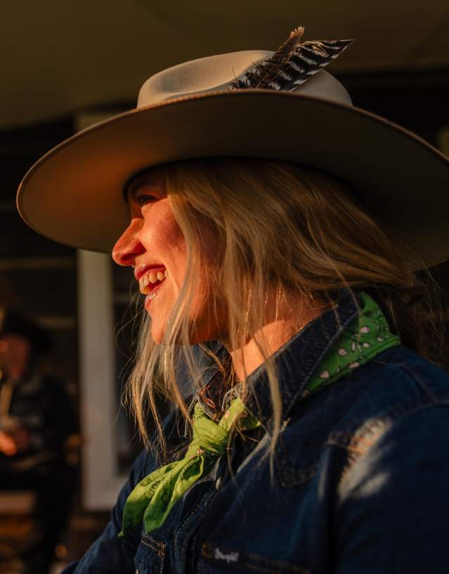 Guests relaxing at a rustic Wyoming dude ranch, with majestic mountain scenery in the background; book your authentic ranch stay today.
