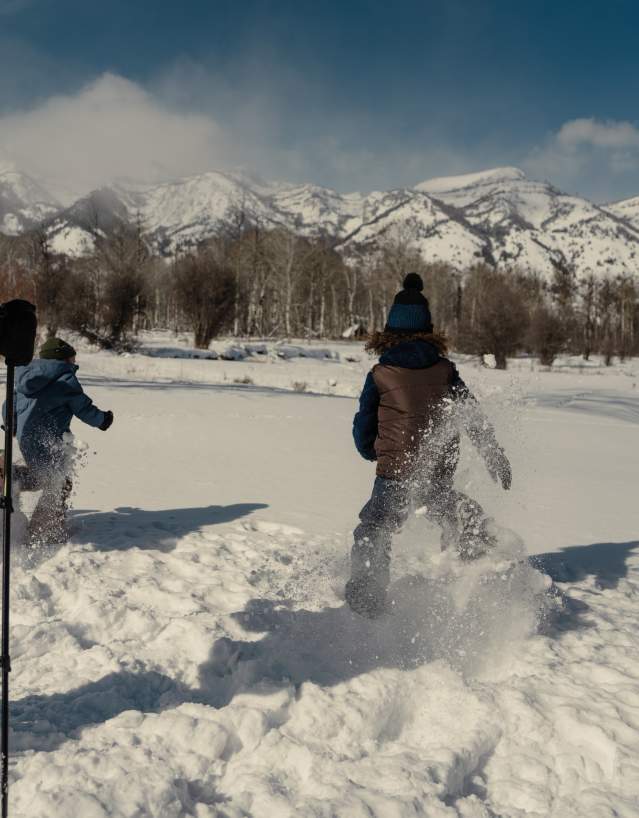 Take your family snowshoeing across a snow covered trail in Wyoming.