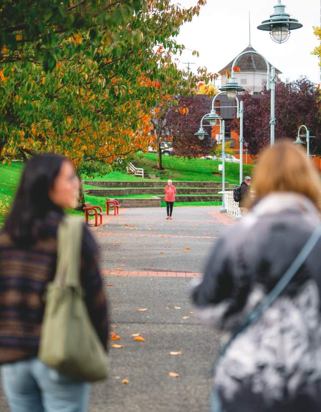Two people walking along the Nanaimo harbour.