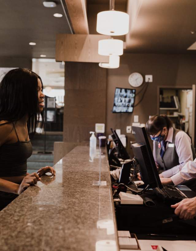 A person checking into the front desk of a hotel.