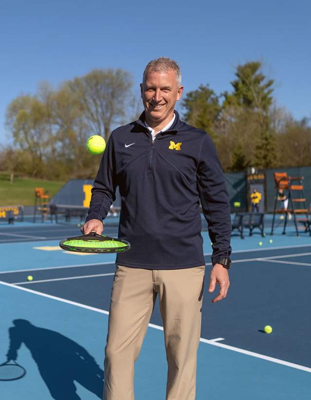 Man bouncing tennis ball with racket- U-M South Complex