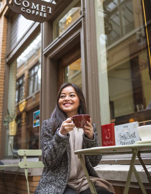 Woman sitting at table outside Comet Coffee