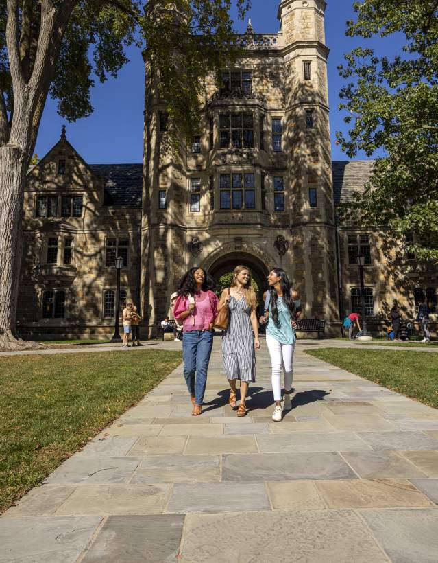 Three college-aged women walking together in U-M Law Quad in Summer
