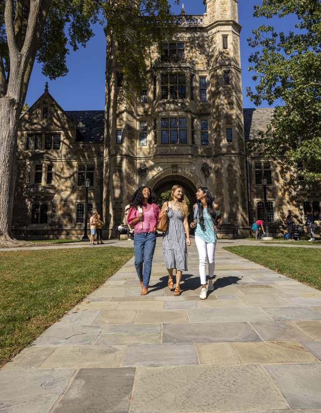 Three college-aged women walking together in U-M Law Quad in Summer