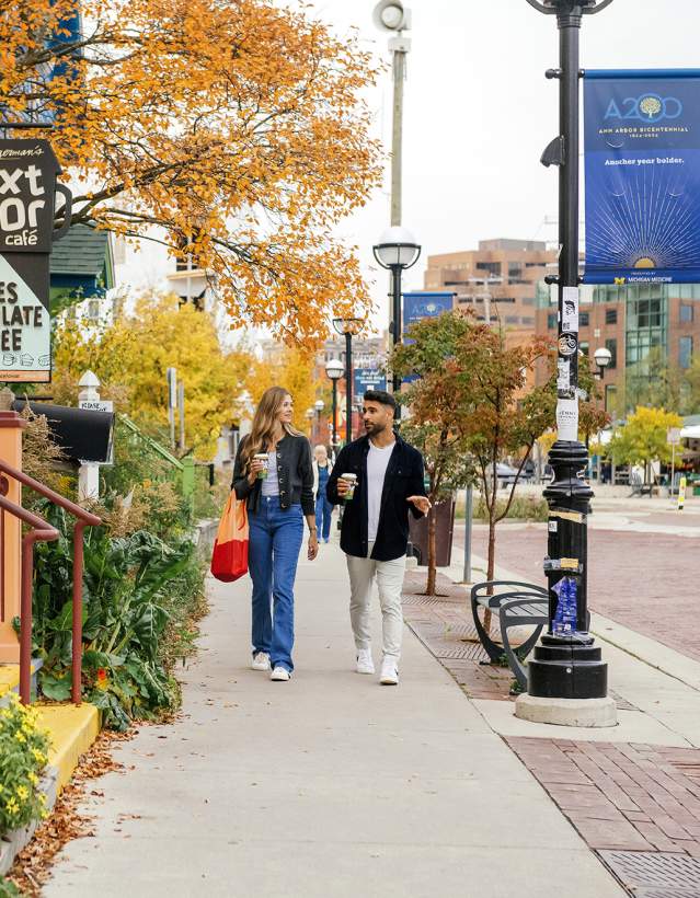 Young couple walking on sidewalk in front of Zingerman's Next Door Cafe'