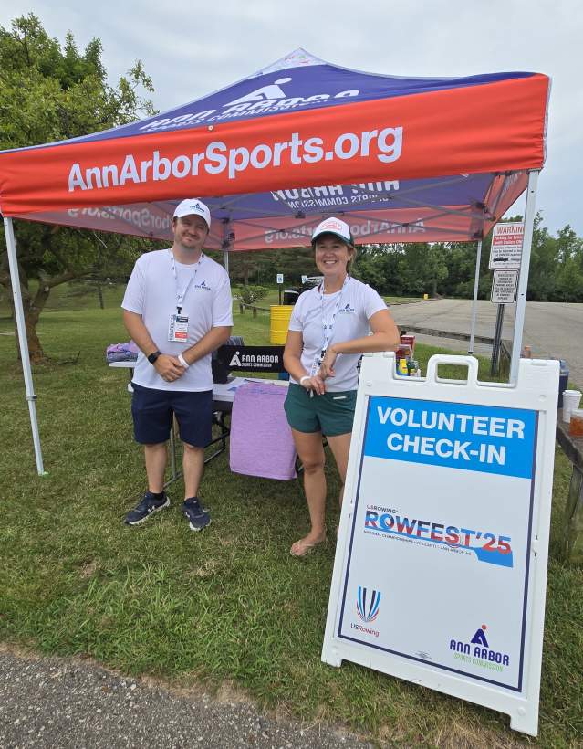 Zack Buck and Meaghan Hughes standing under a AnnArborSports.org tent