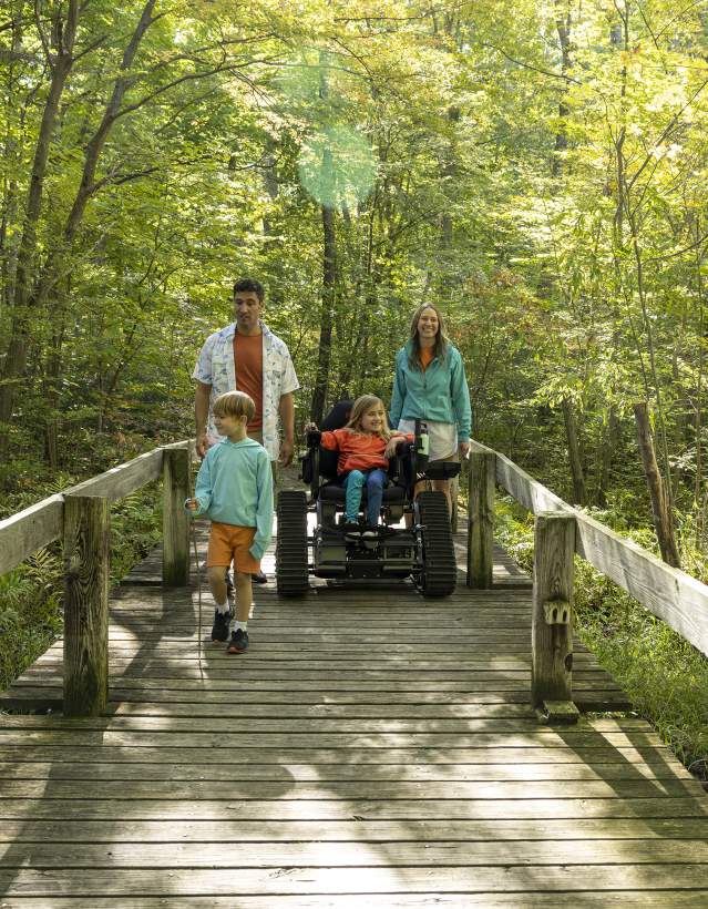 Family with daughter in wheelchair on hiking trail