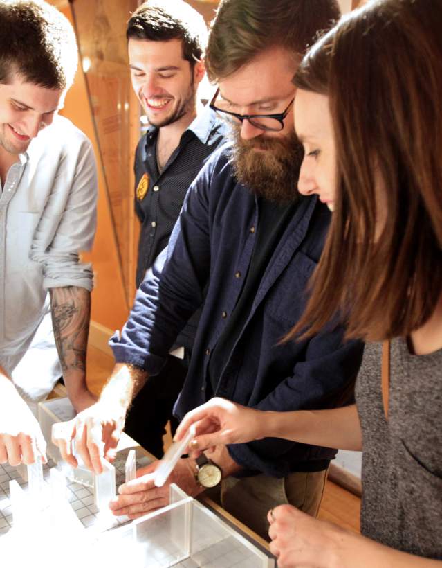 Four adults interacting with a exhibit at the Hands-On Museum