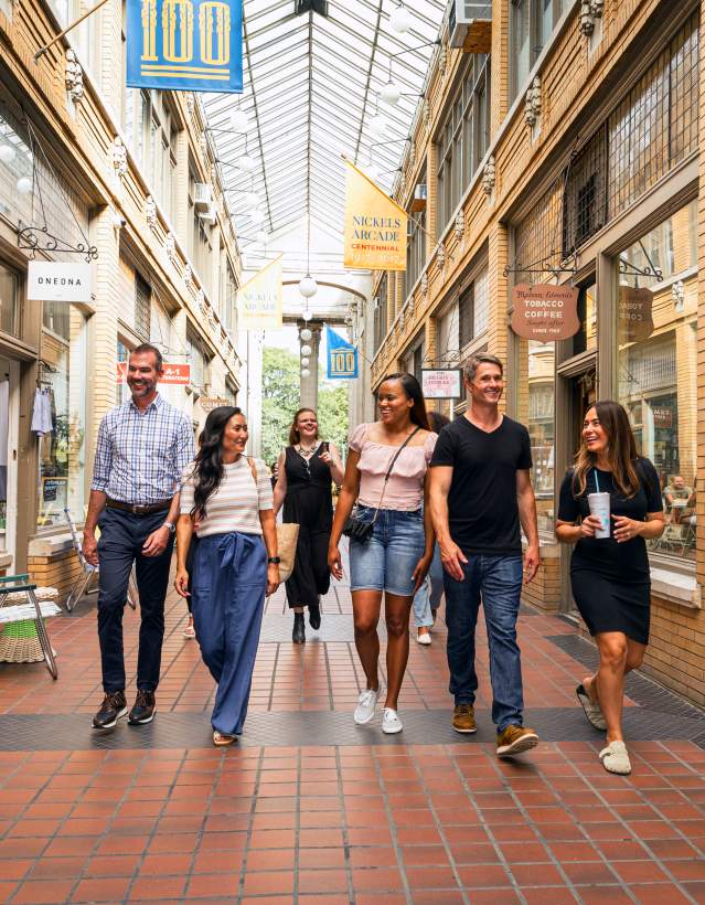 Group of professionals walking through Nickels Arcade covered walkway
