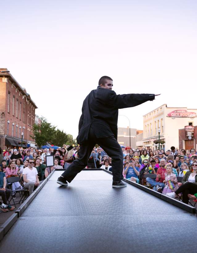 Performer center stage with crowds at Ypsi Pride