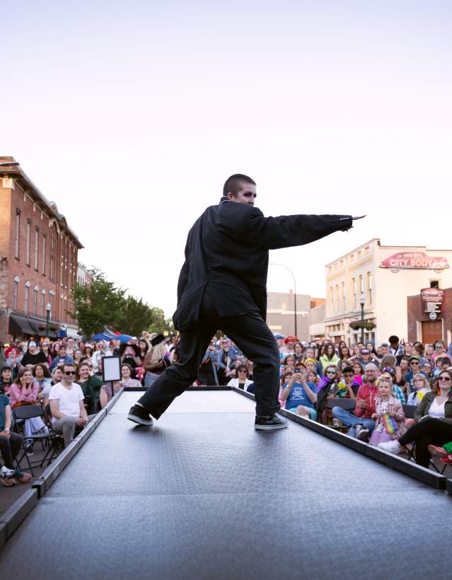 Performer center stage with crowds at Ypsi Pride