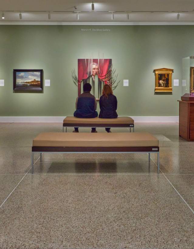 Couple sitting on bench in UMMA looking at painting
