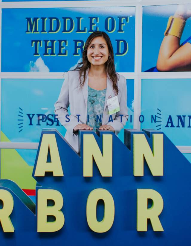 Woman in front of an Ann Arbor logo