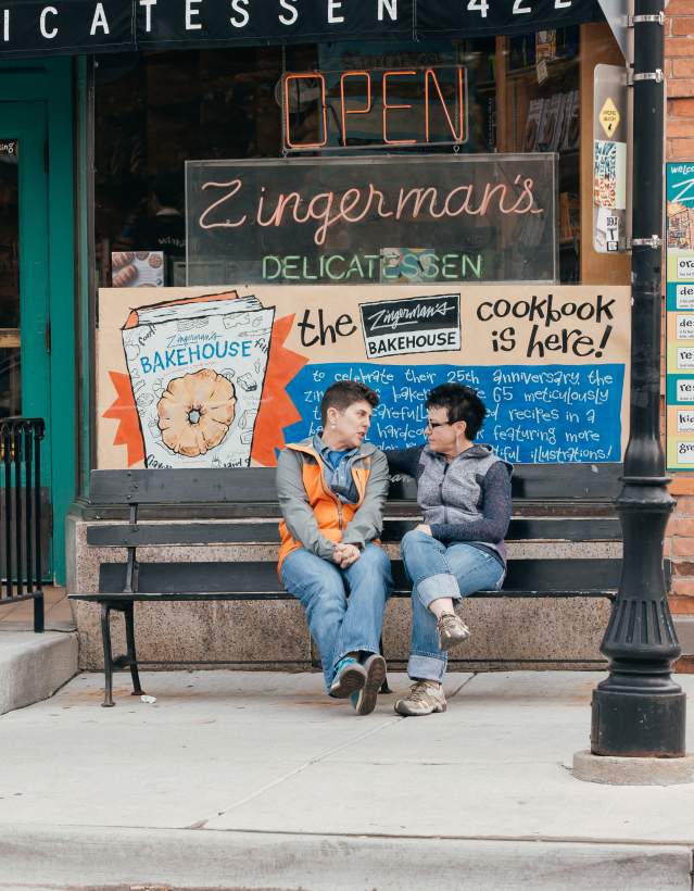 Female couple sitting on bench outside Zingerman's Deli