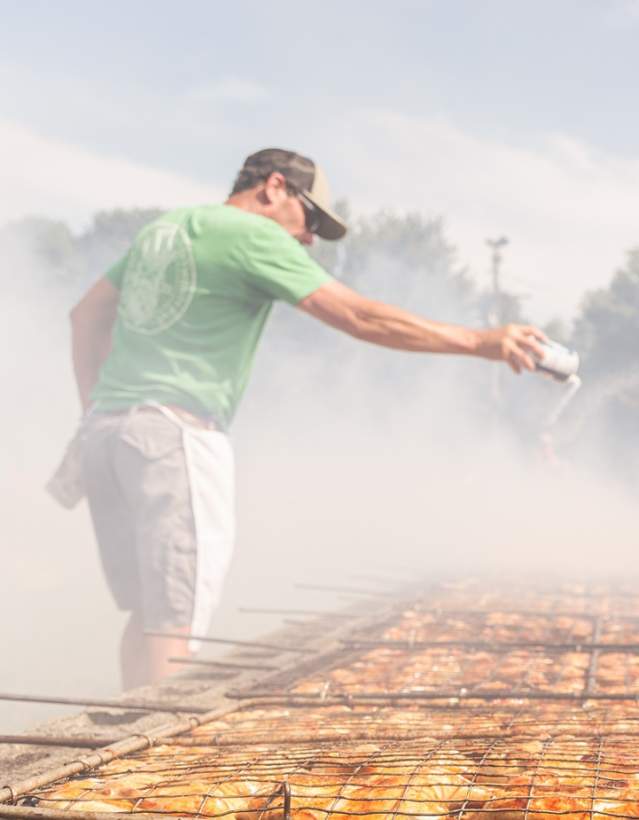 man salting cooked chicken at manchester chicken broil