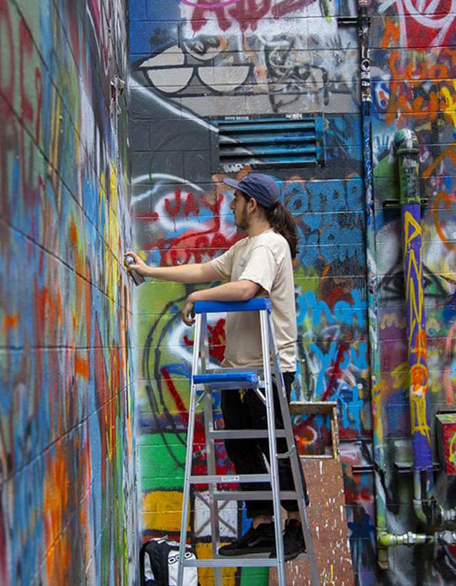 Man spray painting in Graffiti Alley