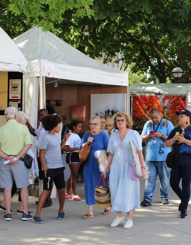People walking in front of art fair booths