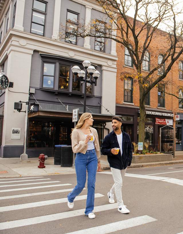 Couple walking across Main Street in downtown ann arbor