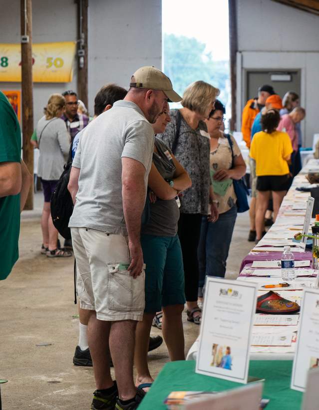 People looking at a table with silent auction items