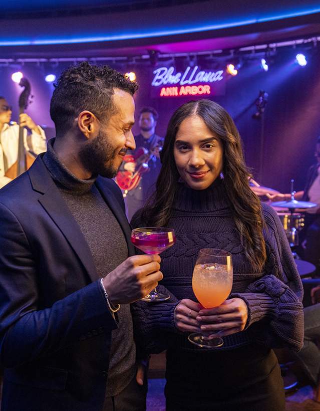 Stylish couple holding drinks at Blue Llama Jazz Club