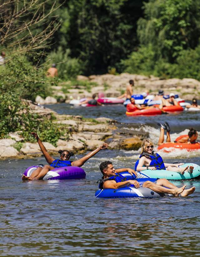 Group of people in colorful inner tubes floating down the river