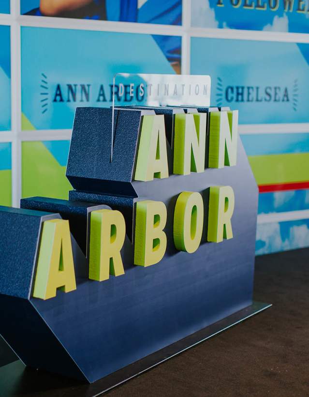Large sculpture of Destination Ann Arbor logo in green and blue