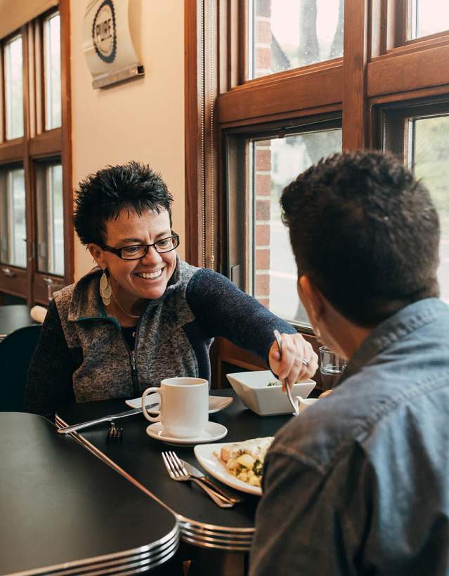 Two women eating at Detroit Street Filling Station