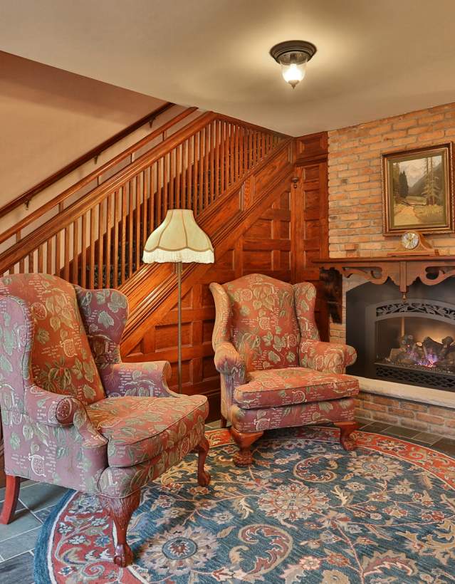 Two chairs by fireplace at Stone Chalet B & B