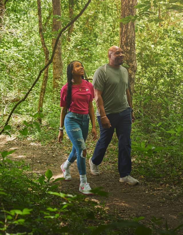 A father and teenage daughter walk along the woodsy trail at Cahaba River Park.
