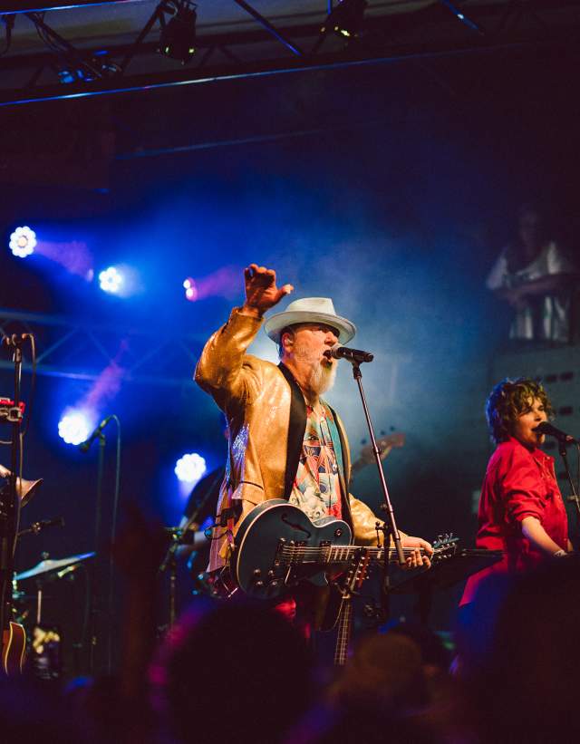 Image of a band onstage at Mohawk with the main man holding his hand up and singing into the microphone.