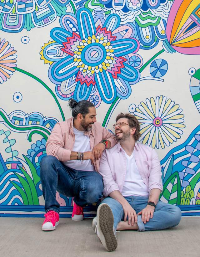 Husbands and owners of Wunderkeks sitting against a mural wall.