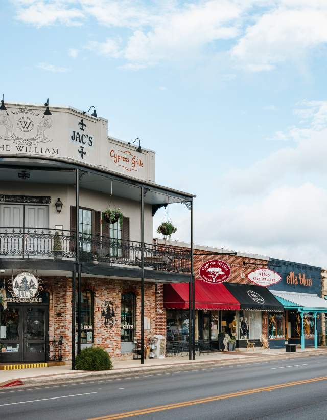 Photo of shops in downtown Boerne, on the Hill Country Mile. Shops include Jac's, Cypress Grille, The Alley on Main, Ella Blue and others