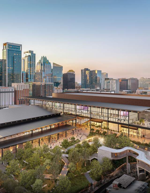 Rendering of the new Austin Convention Center building at sunset with the city skyline in the background. The image shows Waterloo Greenway creek and greenspace in the foreground