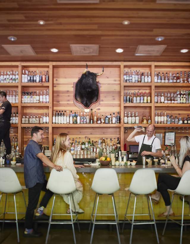 People sitting at bar while bartender shakes cocktail at La Condesa Bar in Austin Texas