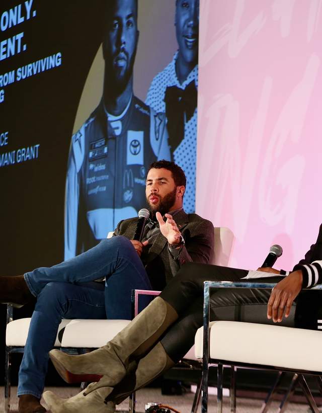 Man and woman on stage in lounge chairs for panel discussion.