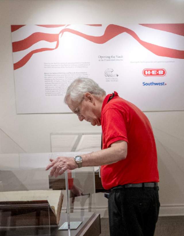Man reading an archival display at the LBJ Presidential Library.