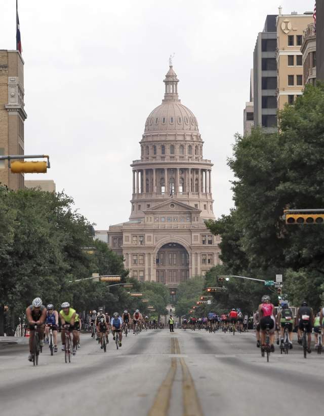 Hundreds of cyclists moving towards and away from the Texas State Capitol on Congress Avenue.