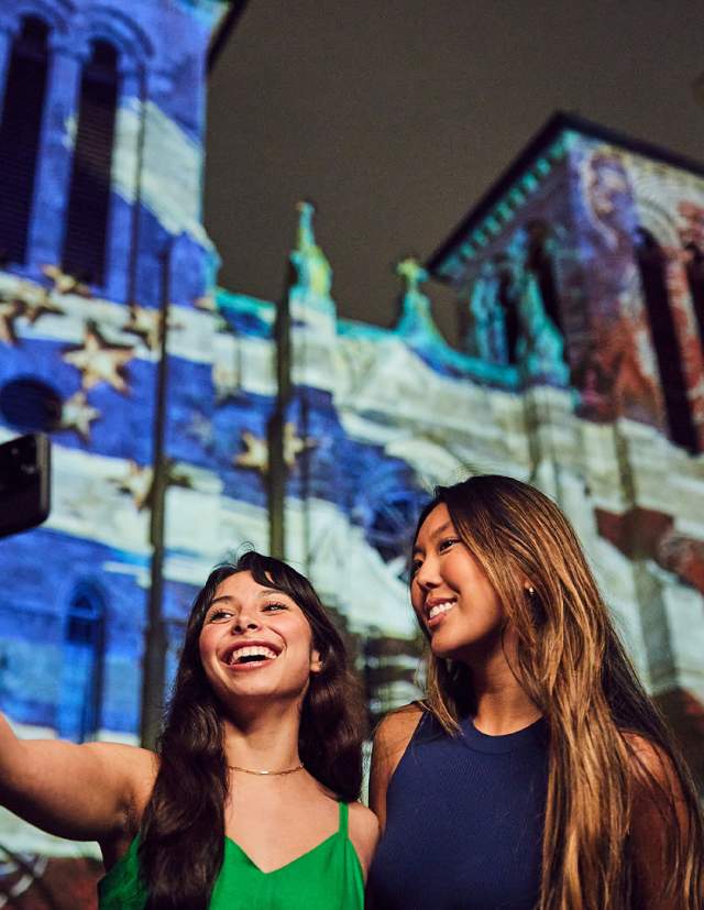 Two girls in front of light show projection