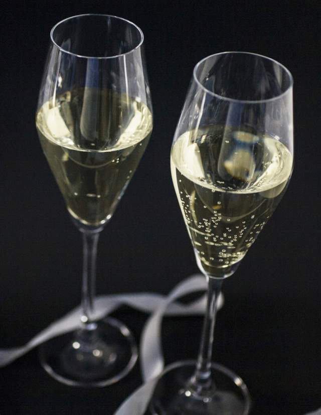 Two champagne glasses on a black table with ribbon to celebrate New Year's Eve in Providence
