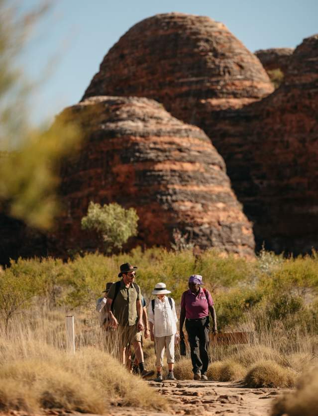 A guide from Kingfisher Tours takes a couple through the striped domes of the Bungle Bungle Ranges