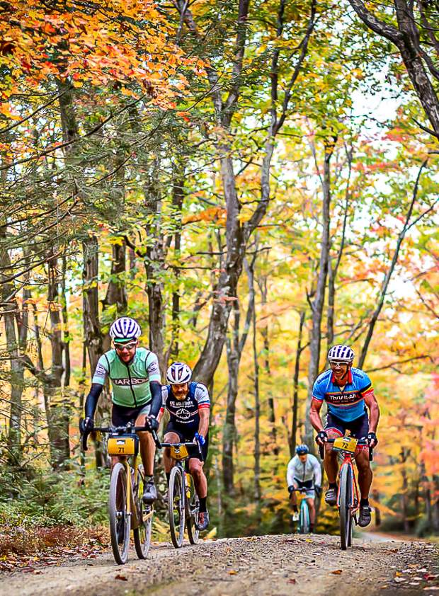 Four unPAved cyclists race through an autumn forest.