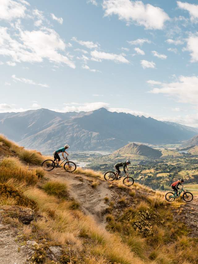 Three mountain bikers on Pack Track and Sack Trail, Coronet Peak