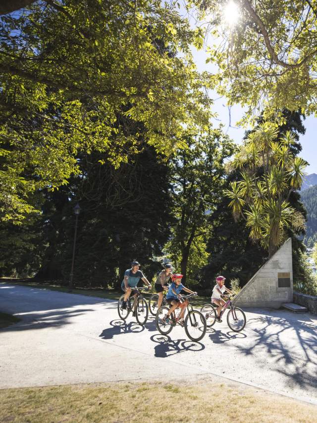 A family biking in the Queenstown Gardens